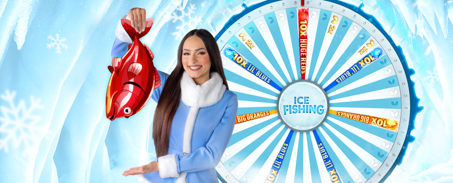 Smiling live casino host holding a red cartoon fish in front of the Ice Fishing game wheel – exclusive Arctic-themed experience. - foxybingo